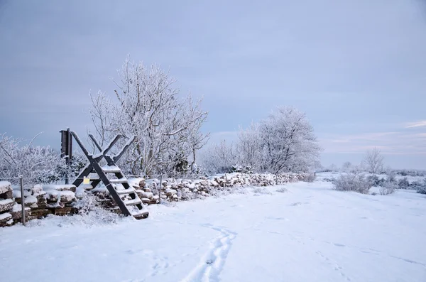 Winterland med en stile på en stenmur — Stockfoto