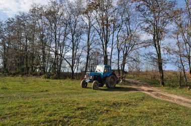 Traktör ayakta ağaçlar yakınındaki