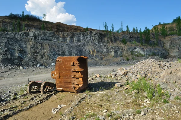 Excavator shovel is in his career between the stones and sand — Stock Photo, Image