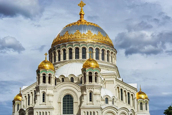 Donanma Nikolsky Katedrali 'nin kubbeleri, Kronstadt şehrinde altın kaplama ve haçlarla dolu bir yaz gününde gri bulutlu bir gökyüzünün arka planına karşı..