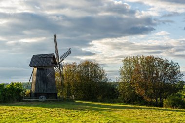 Güneşli bir günde gri bulutlu gökyüzünün arka planında eski ahşap değirmen.