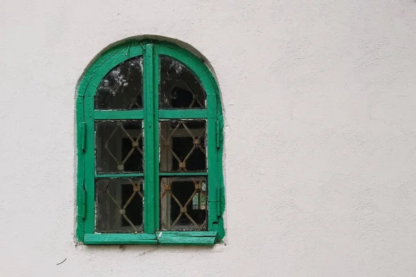 緑の木枠と淡い灰色の壁に対する鉄の棒でアーチ型の窓 世界シリーズの窓から — ストック写真