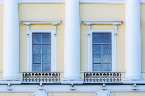 Dos Ventanas Rectangulares Con Columnas Blancas Contra Una Pared Amarilla Imagen De Stock