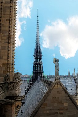 Notre Dame Katedrali 'nin ve mavi gökyüzüne karşı heykellerin manzarası.