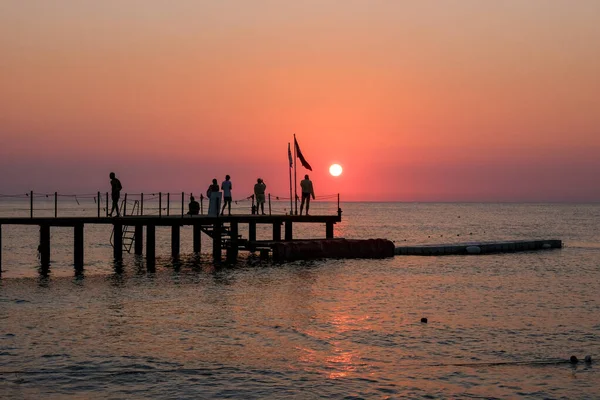 Prachtige zonsondergang zonsopgang strand met roze hemel en pier. Reizen, ontspannen en meditatie concept — Stockfoto