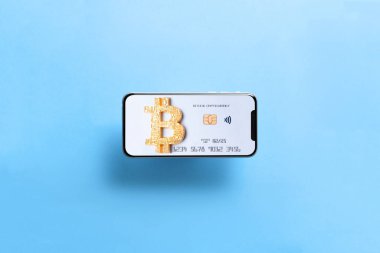 Bitcoin kartı olan akıllı telefon. Üzerinde Bitcoin ödeme sembolü olan yeni siyah çerçevesiz akıllı telefon. Banka bitcoin şifreleme kartı alışveriş ve ticaret konsepti olarak.
