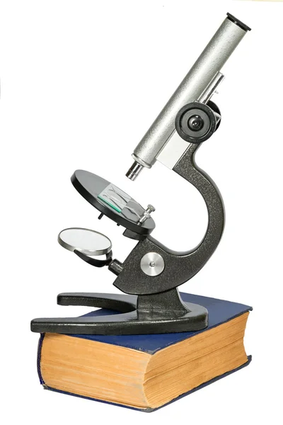 Mikroskop ayakta beyaz izole kalın eski kitap — Stok fotoğraf