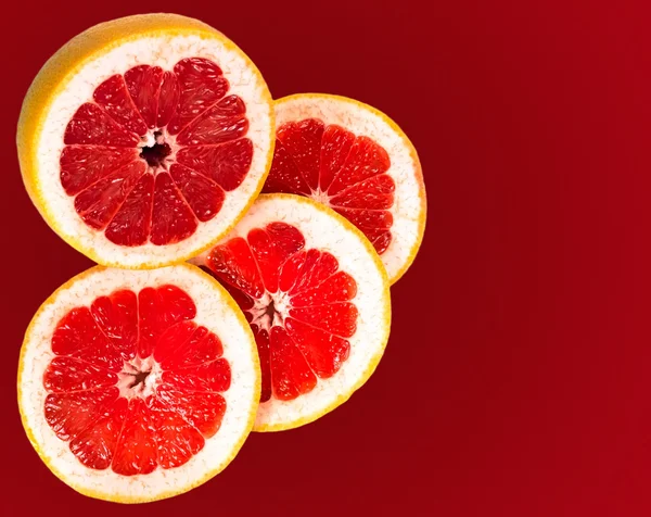 Свежий грейпфрут и ломтики, выделенные красным градиентом — стоковое фото