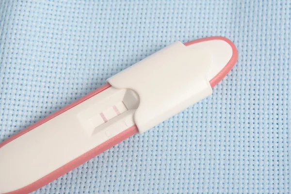 Pacchetto test di gravidanza su sfondo blu — Foto Stock