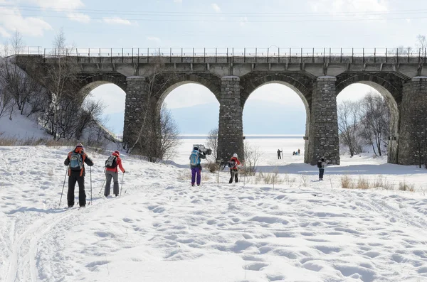 Turistas-esquiadores pasan por debajo del puente ferroviario Circum-Baikal — Foto de Stock