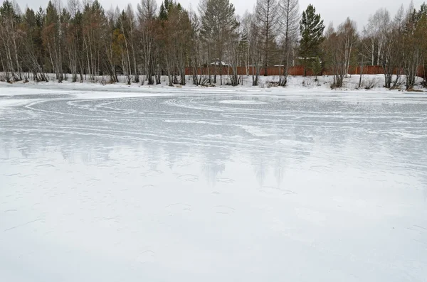 Rivière glacée par une journée de printemps nuageuse dans le village — Photo