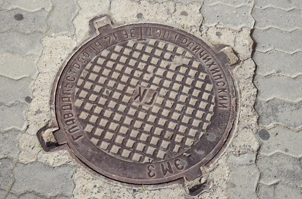 Chita, RU - Jul.17,2014: Cast iron manhole cover of urban sanitation in tha city of Chita — Stock Photo, Image