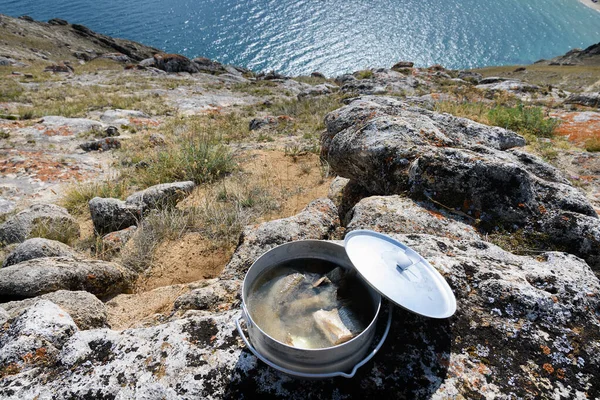 Baikal fish soup with grayling and omul, cooked on the rocky shore above the Aya Bay 스톡 사진
