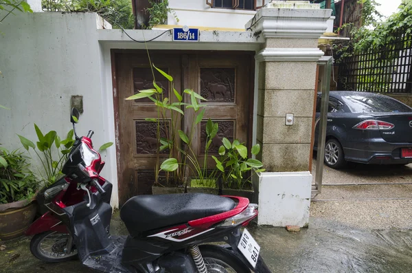 Motorkerékpár közelében az ajtók fából készült dekorációk. Thaisz, Phuket-ház — Stock Fotó