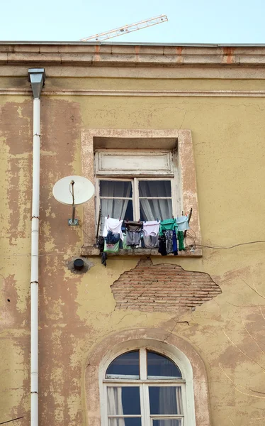 Las ventanas de una casa de apartamentos y lavandería en un tendedero —  Fotos de Stock