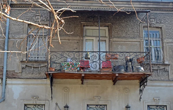 Balcón de hierro forjado de una casa de apartamentos con sillas rojas. Tiflis, Georgia — Foto de Stock