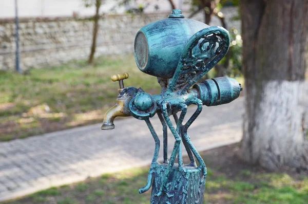 Telavi, Georgia - Feb, 28 2015:Mosquito-faucet with keg - part of the original bench-sculpture in Telavi. Georgia — стокове фото