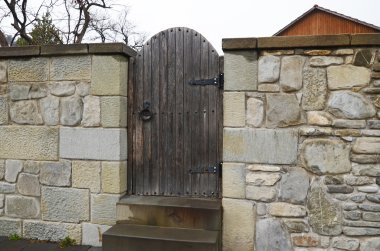 The stone fence with wooden gate on Mtskheta street. Georgia