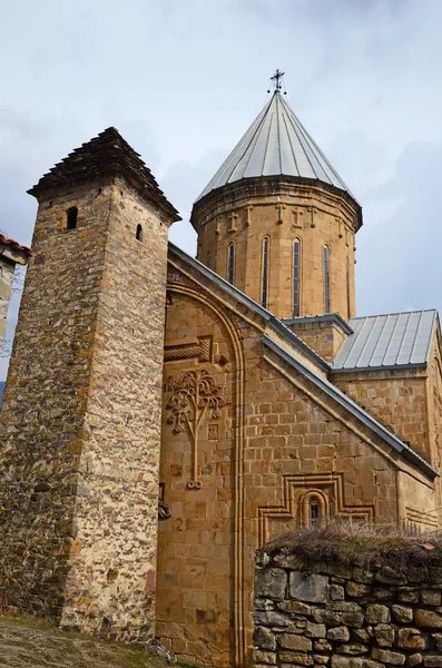 Tour du XIII siècle et le mur de l'église de l'Assomption avec une vigne sculptée et une croix sur le devant. Le château d'Ananuri. Géorgie — Photo