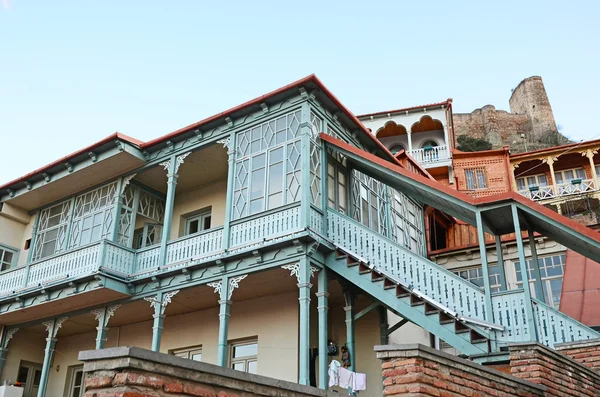 Blue carved wooden balcony under city fortress hill. Tbilisi, Old Town — Stock Photo, Image