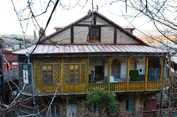 Vanha talo veistetty puinen keltainen parveke Tbilisissä, Vanhassa kaupungissa — kuvapankkivalokuva
