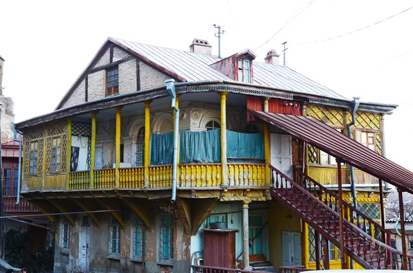 Old house with carved wooden yellow balcony and staircase in Tbilisi, Old Town — Stock Photo, Image