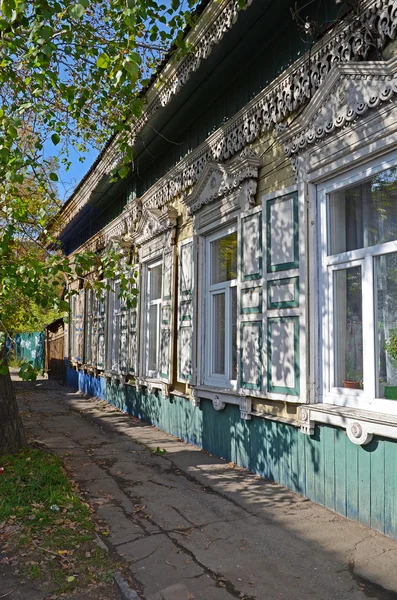 Lacy houten huis met blinden van het venster in de schaduw van de bladeren — Stockfoto