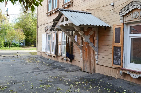 Twee verdiepingen tellend houten huis met veranda en venster luiken op Irkoetsk street — Stockfoto