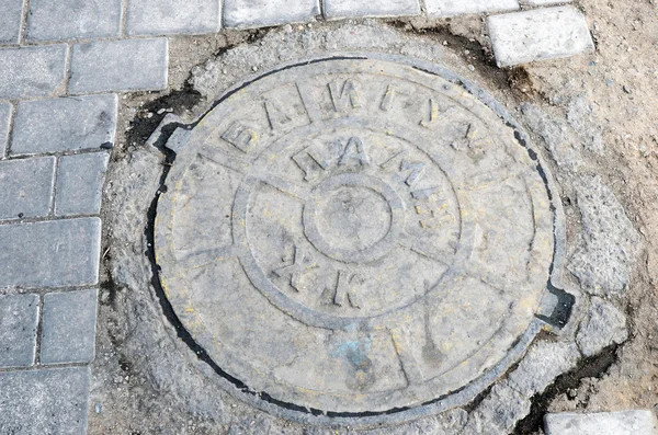 The hatch of urban sewerage with the inscription in the Mongolian language.   Ulaanbaatar, Mongolia — Stock Photo, Image