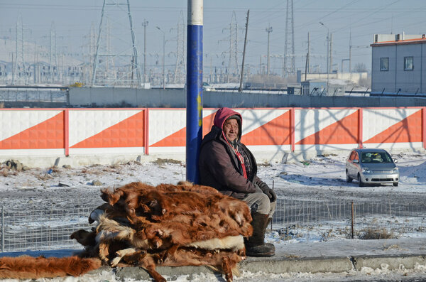 Ulaanbaatar, Mongolia - Dec, 03 2015: Man sells cowhides on the side of the road in Mongolia