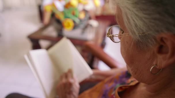 Libro de lectura de señora de 9 años en sillón en hospicio — Vídeos de Stock