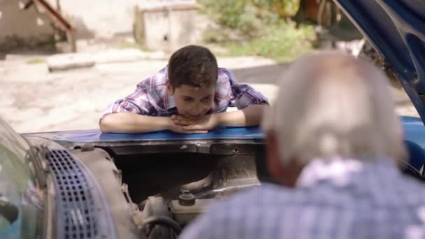 年配の男性からおじいちゃん学習車エンジンを持つ 3 少年 — ストック動画