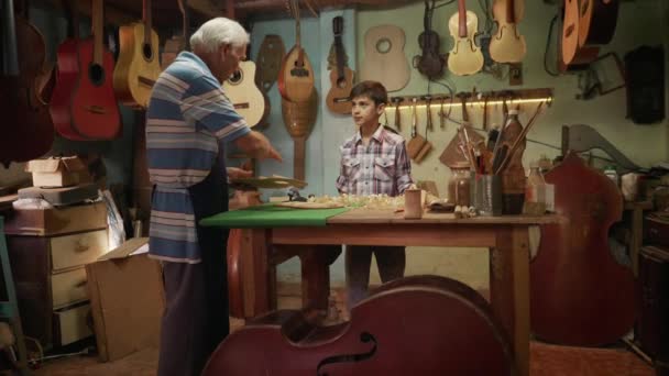 6-Lute Maker Abuelo Enseñando Nieto Chiseling Madera — Vídeo de stock