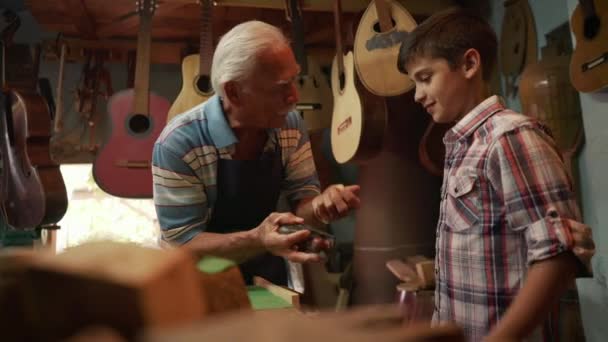 7-летний создатель лютни обучает внука Чизелинг Вуд — стоковое видео