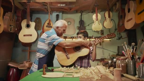 13-Boy impara a suonare la chitarra con anziano uomo nonno — Video Stock