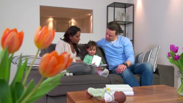 Multiétnico casal leitura livro para criança homem mulher filha bebê — Vídeo de Stock