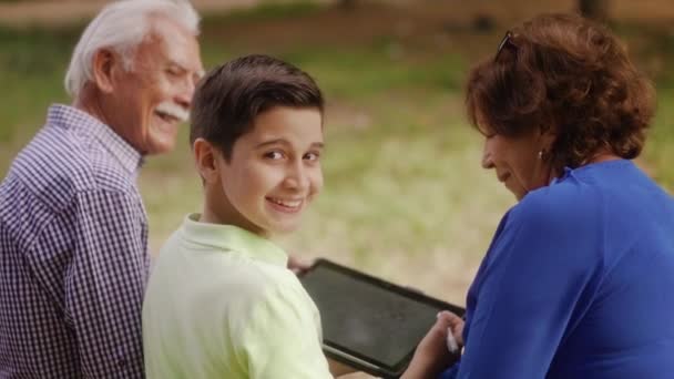 Menino feliz estudando escola lição de casa com avós — Vídeo de Stock