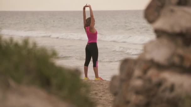 5aktivní mladá žena dělá Fitness táhnoucí se na pláži — Stock video