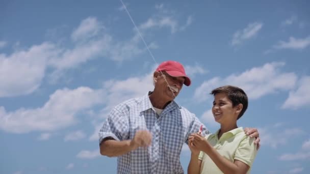 18-Abuelo de la familia que enseña al muchacho a volar la cometa en cámara lenta — Vídeos de Stock