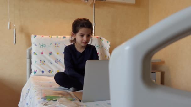 病院の部屋でラップトップPcで勉強している病気の女の子 若い女性学生はコンピュータで遠隔学習します 学校の宿題をしている子供 Covid 19隔離の間のEラーニング クリニックでの教育 — ストック動画