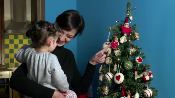 Feliz madre e hija mirando el árbol de Navidad en casa — Vídeo de stock