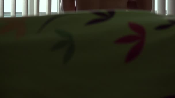 Женщина одевается в футболку утром в спальне — стоковое видео