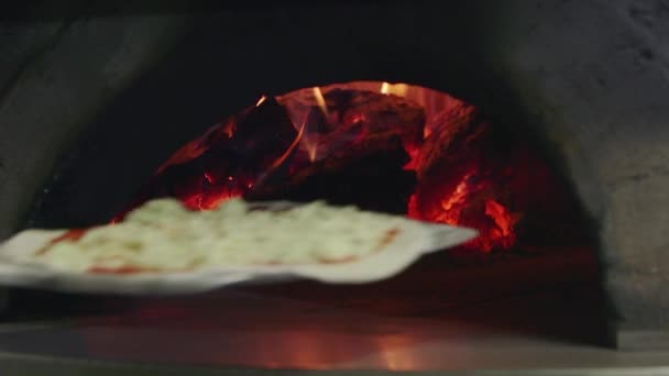 Cuisson de pizza dans le feu de bois de four de cuisine de restaurant italien 