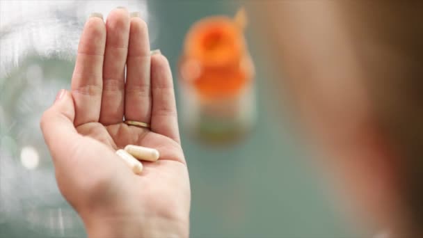 Молодая женщина принимает витамины таблетки — стоковое видео