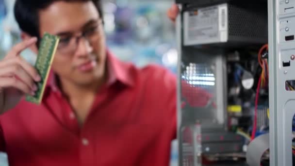 Porträt eines Chinesen, der PC in Computerladen repariert — Stockvideo