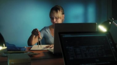 Gece geç saatte ofiste çalışan yorgun gözlü kadın