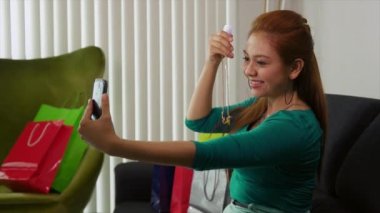 Latina kız alışveriş torbaları ile telefon Selfie alarak ile