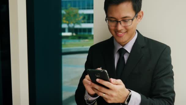Бизнесмен пишет ручкой на дисплее мобильного телефона — стоковое видео