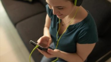 Kadın cep telefonu ile müzik Podcast kulaklık dinler