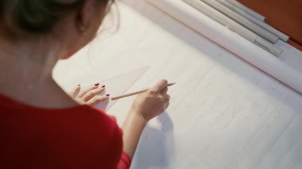 Девушка стирает линии на чертеже в студии — стоковое видео